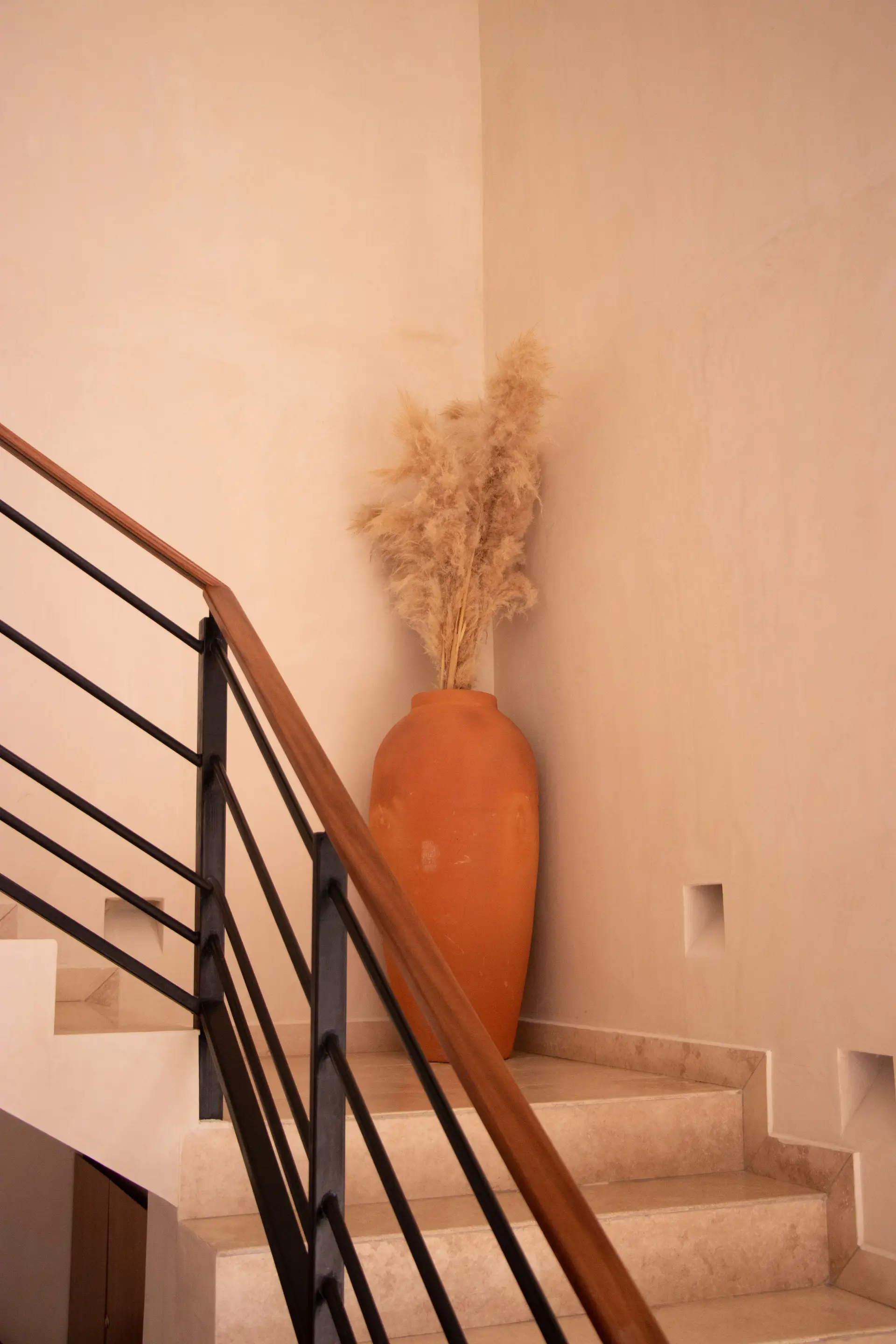 Minimalist staircase niche with terracotta vase and pampas grass
