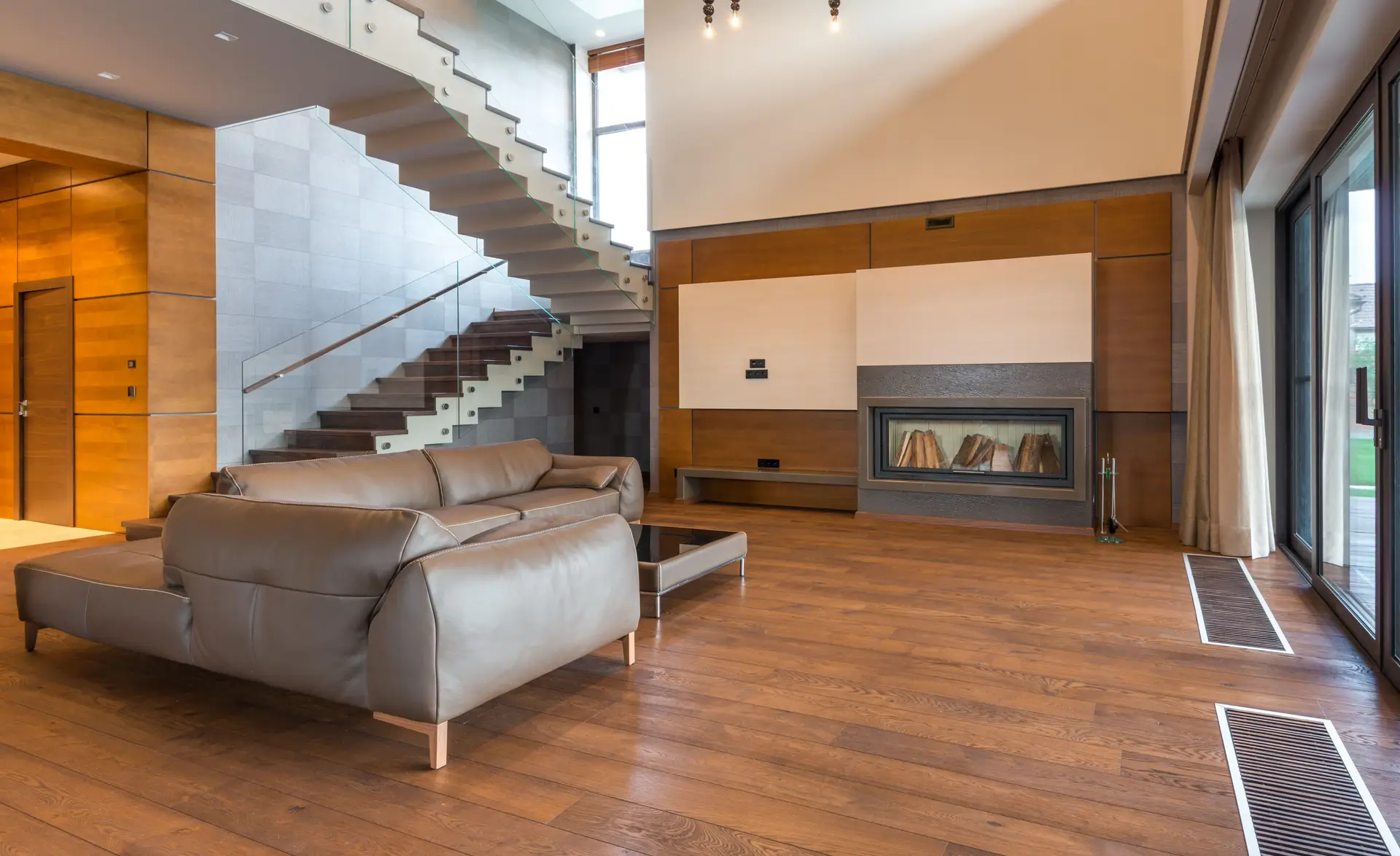 Main salon view showing the integrated stone hearth and custom upholstered lounge chairs